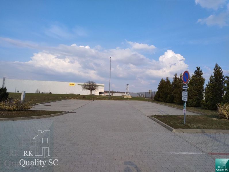 Exterior in Senec with offices, parking lot, and blue sky.