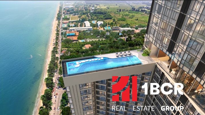Apartments construction in Pattaya with a swimming pool and a view of the sea and beach.