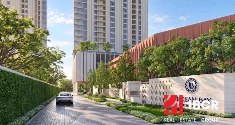 Apartment construction in Pattaya with a high-rise building, greenery, and a car on the driveway.