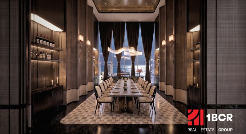 A luxurious dining room with a long table and a view of the city in an apartment development.