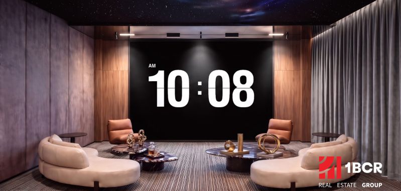 An interior space with clocks, sofas, and coffee tables as part of apartment construction.