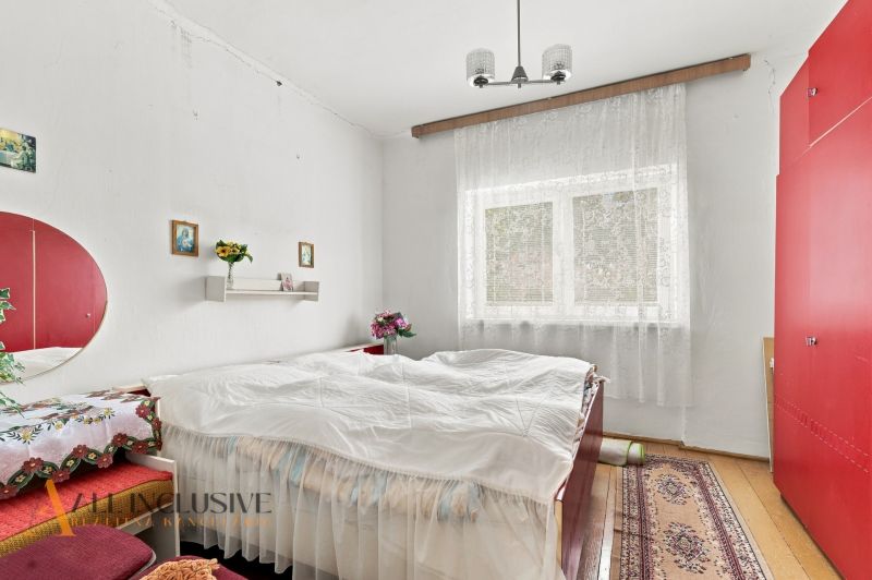 A bedroom in a family house with white walls, red cabinets, and decorations.
