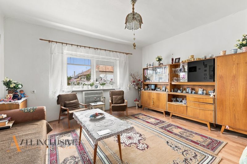 Living room in a family house with a sideboard, armchairs, and a wooden decor floor.