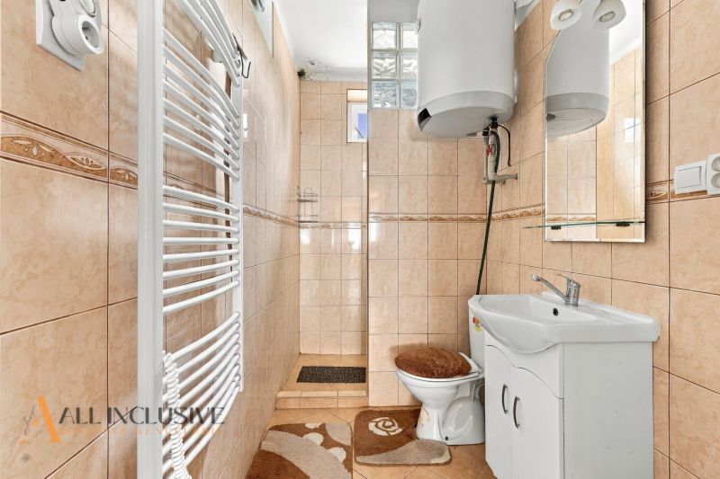 A bathroom in a family house with tiles and white furniture.