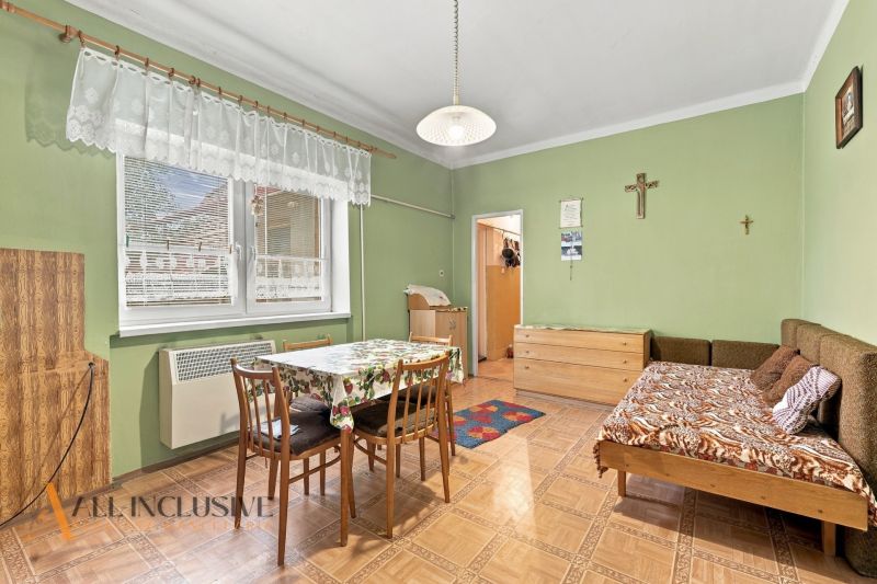 A room in a family house with a wooden decor floor and green walls.