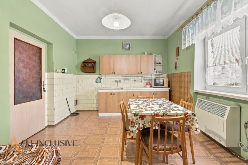 A kitchen in a family house with a simple interior and a floor with a wooden decor.