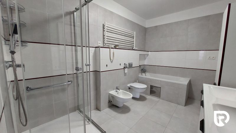 A bathroom in a 2-room apartment with a bathtub, shower, and toilet.