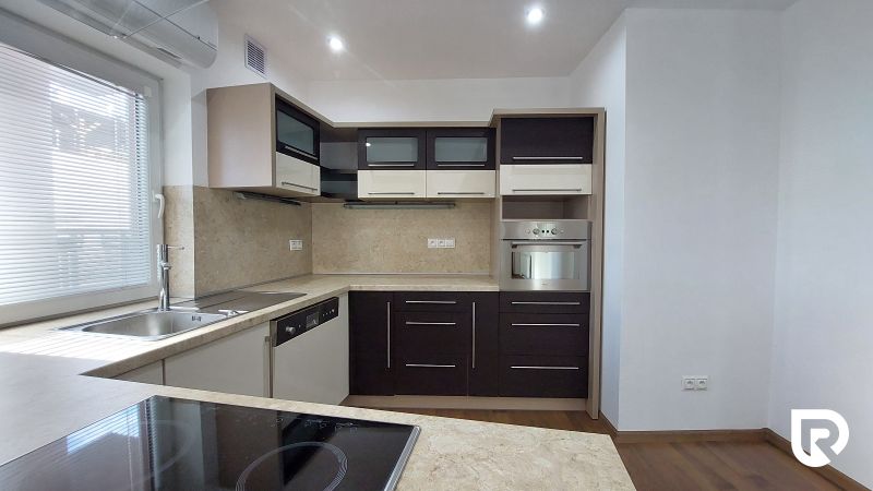 A corner kitchen layout in a 2-room apartment with a wooden decor floor.