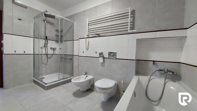 Bathroom with a bathtub, shower, and bidet in a 2-room apartment.