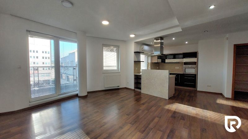 Spacious interior of a 2-room apartment with a kitchen and a wooden decor floor.