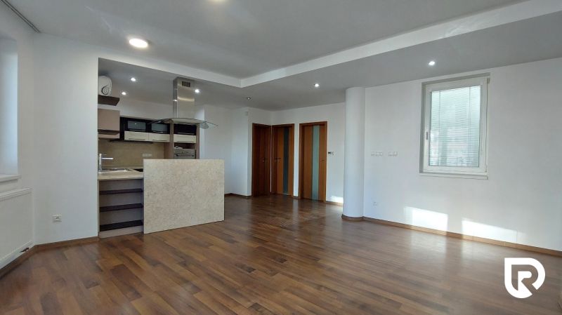 Open space with a kitchen, wooden decor flooring in a 2-room apartment.