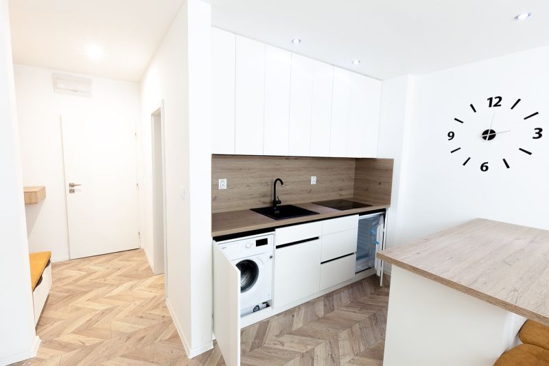 A modernly furnished kitchen with a wooden decor floor in a holiday apartment.