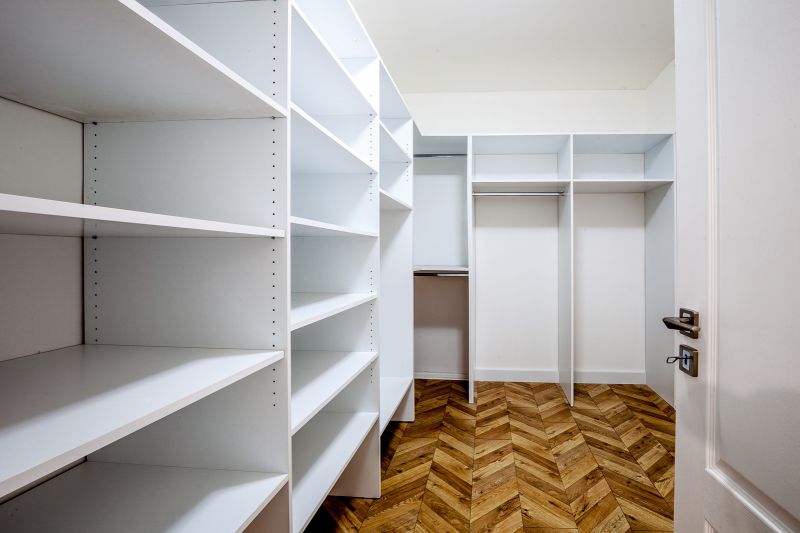 A wardrobe with white shelves and a wooden decor floor in a holiday apartment.