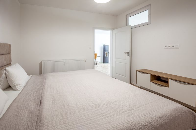 A bedroom in a holiday apartment with a comfortable bed and furniture with a wood decor.