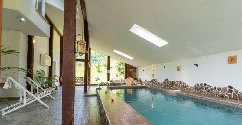 A pool with loungers and stone details in a holiday apartment.