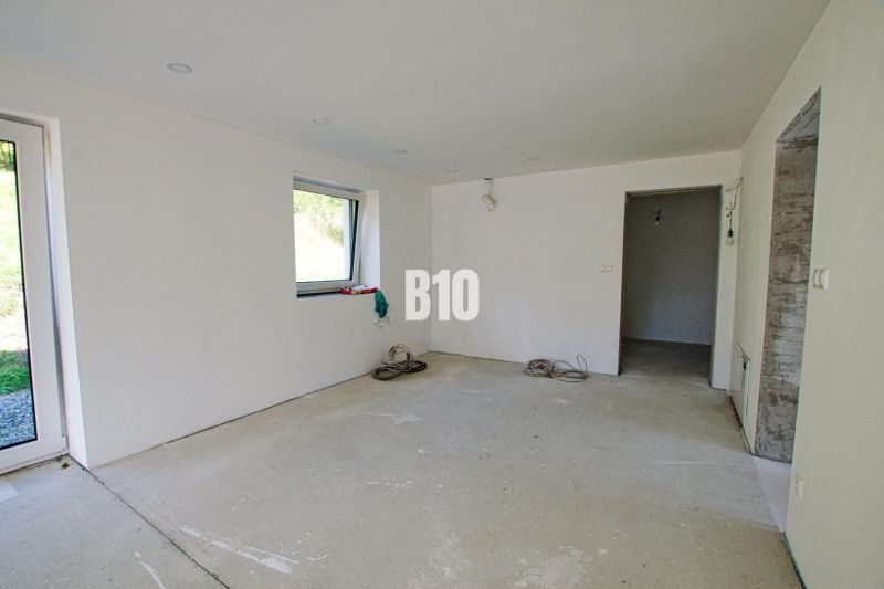 A view of an unfinished room in a family house with a concrete floor.