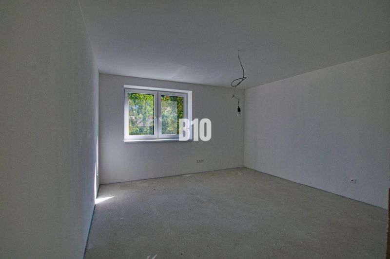 Empty room in a family house with a concrete floor and a large window.