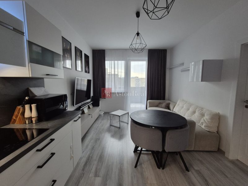 Living room of a three-room apartment with a wooden decor floor and cozy furniture.