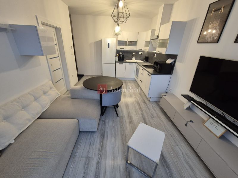 Living room in a 3-room apartment with a kitchenette and a wooden decor floor.