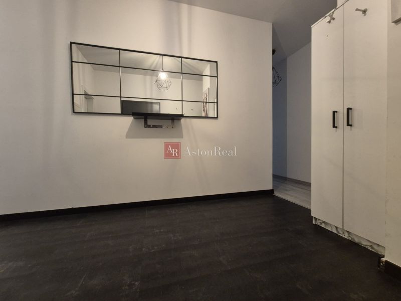 Mirror in a 3-room apartment, floor with wood decor, white cabinets.