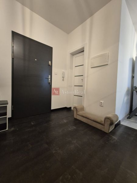 A corridor with a dark floor and light walls, furnishings in a 3-room apartment.