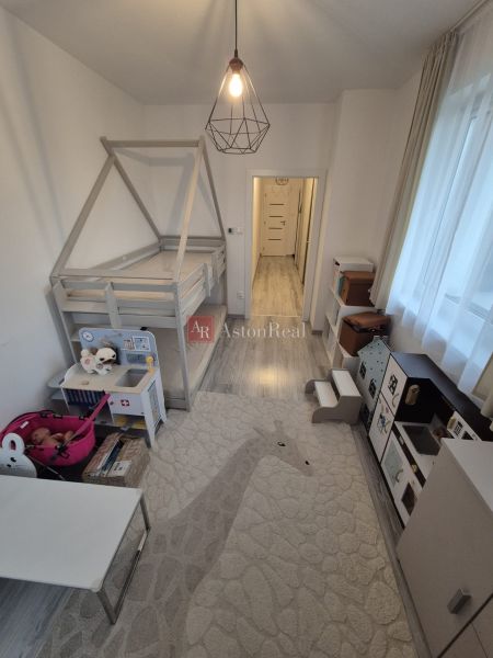 A children's room with a house-shaped bed, toys, and a kitchenette in a 3-room apartment.