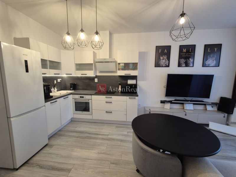 A kitchen unit with a wooden decor floor in a 3-room apartment with stylish lamps.