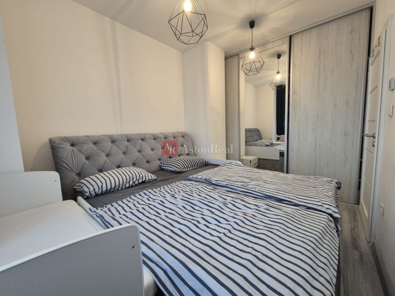 A bedroom with a large upholstered bed and a built-in wardrobe in a 3-room apartment.