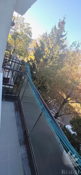 The balcony of a 3-room apartment on Sečovská Street in Bratislava - Ružinov with a view of the trees.