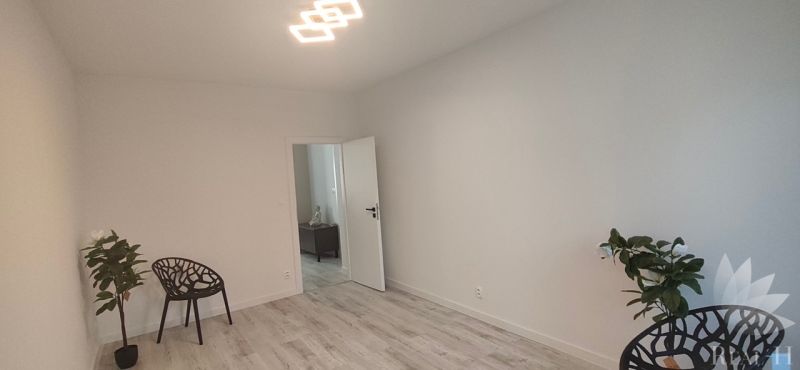 A bright room with chairs and a wooden decor floor in a 3-room apartment.