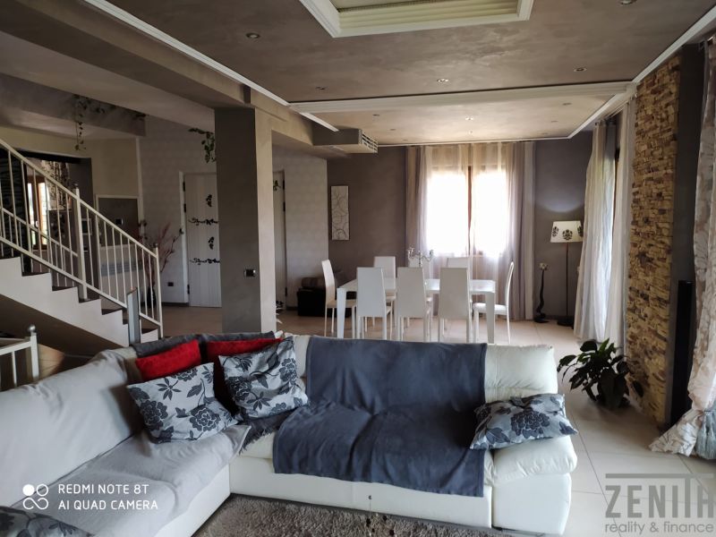 Living room of the villa with white chairs and comfortable seating.