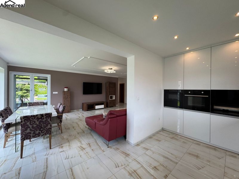 Living room with dining area and kitchen unit in a family house.