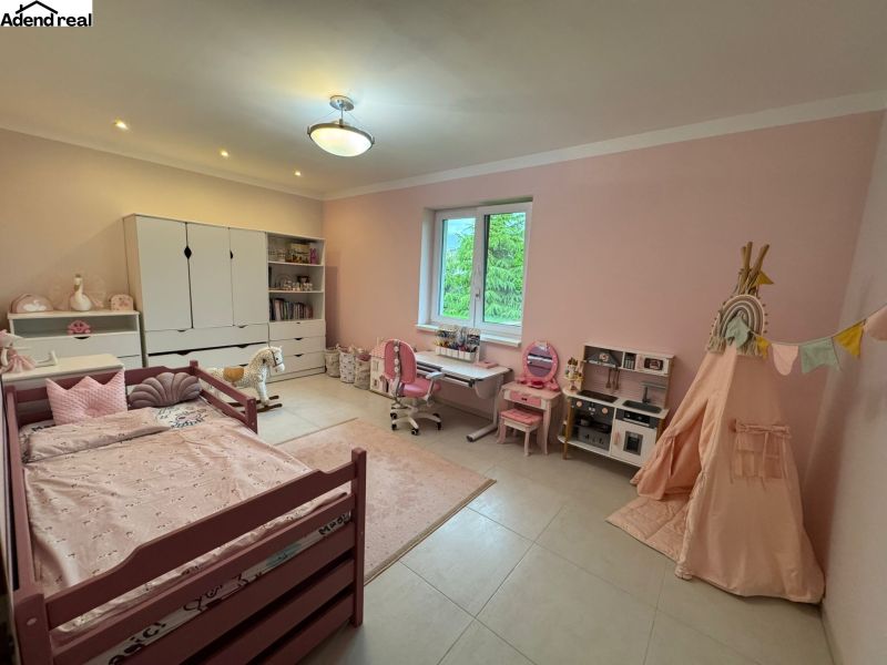 A children's room in a family house with pink walls, a crib, and toys.