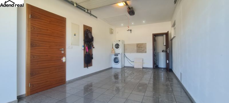Laundry room in a family house with a washing machine and dryer on tiles.