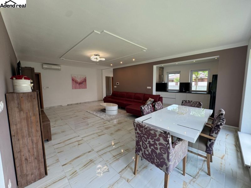 Living room in a family house with a white dining table and a sofa.