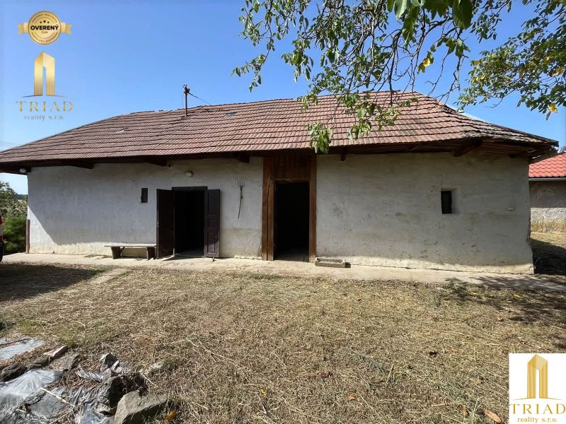 A cottage in Čaka with an old roof, double doors, and a large yard.