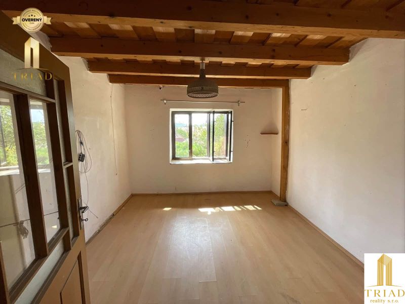 A room in a cottage with a wooden ceiling and a floor with a wooden decor.