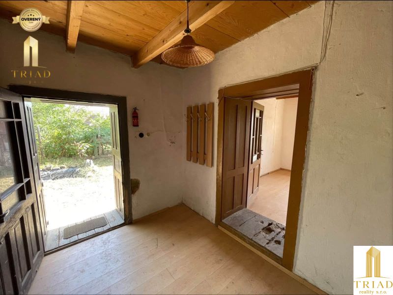 Charming cottage interior with wood-decor flooring and a view of the outdoor yard.