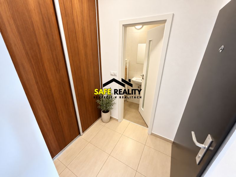 Entrance hallway with white walls, built-in wardrobe, and bathroom door in a 2-room apartment.