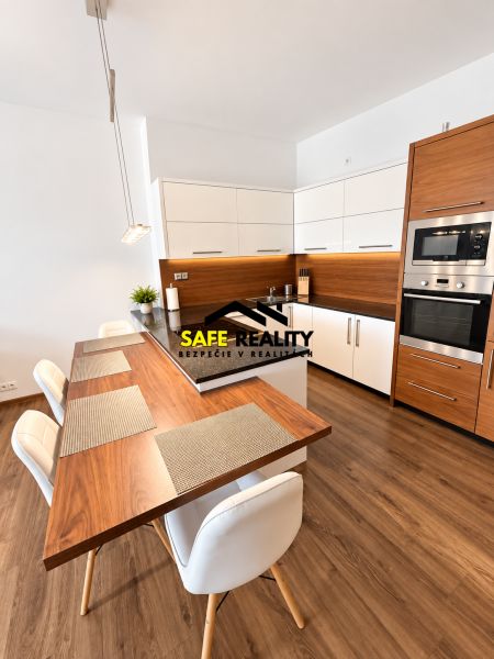 A kitchen in a 2-room apartment with wooden decor and white furniture.