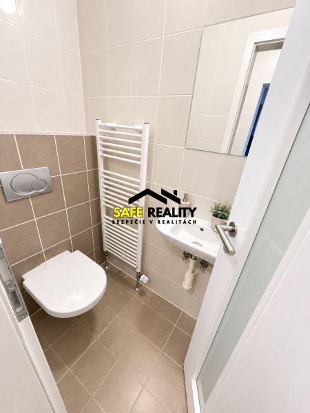 Bathroom with wall-hung toilet, mirror, and ladder radiator in a 2-room apartment.