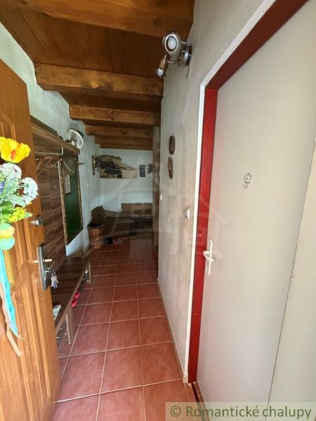 The interior of a cabin with a wooden ceiling, tiles, and wooden decoration on the wall.