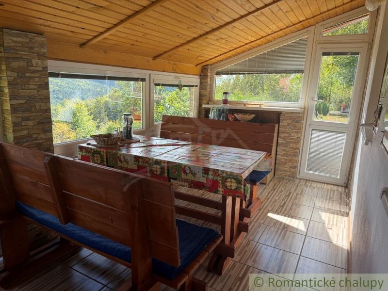 A cottage with a view, wooden furniture, and a floor with a wooden decor, surrounded by nature.