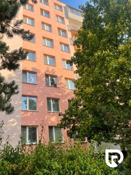 Apartment building on Žilinská Street in Trenčín, hidden behind greenery and trees.