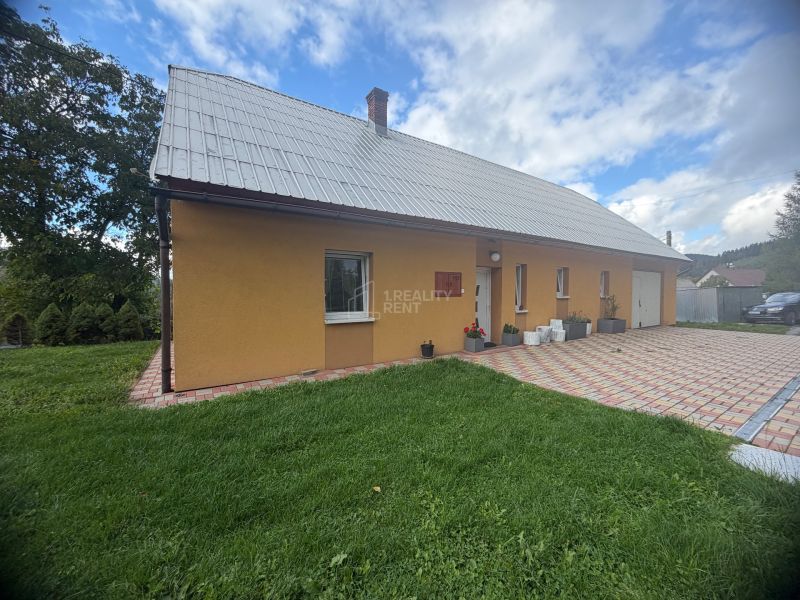 A family house on Košariská Street in Oščadnica with a lawn and a paved terrace.