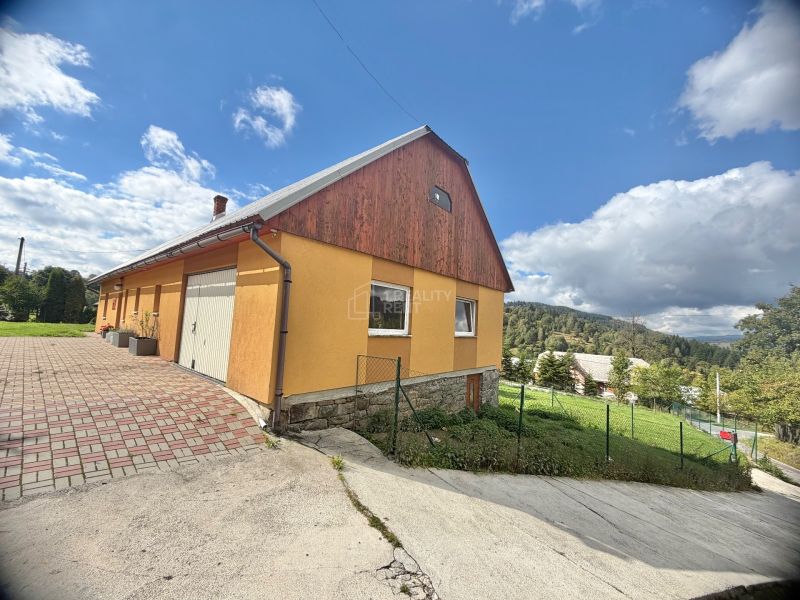 A family house on Košariská Street in Oščadnica, surrounded by greenery and blue skies.