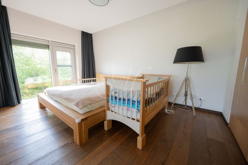 A bedroom with a crib and a large lamp in a 4-room apartment, floor with a wooden decor.