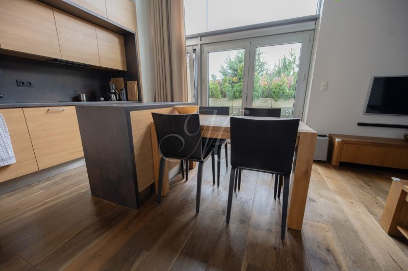 A kitchen in a 4-room apartment with a wooden decor floor and modern furniture.