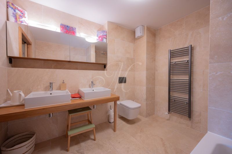 A bathroom with a double sink, mirror, and large-format tiles in a 4-room apartment.