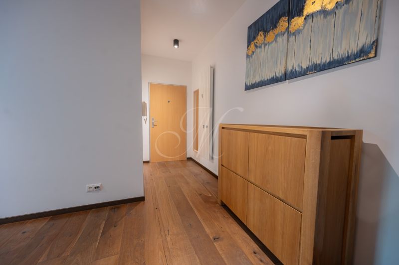 A hallway with a cabinet and a wooden decor floor in a 4-room apartment.